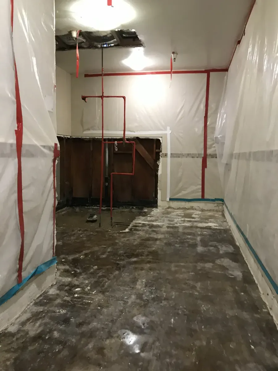 Defined bathroom renovation work area at a Newport Beach care facility