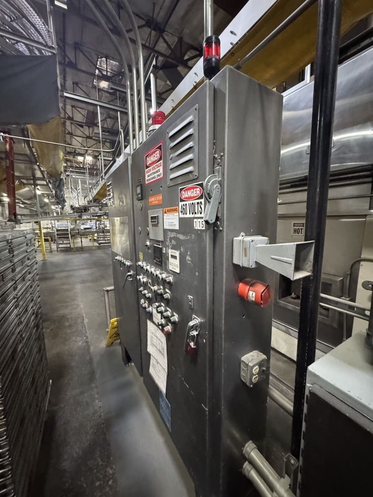 Industrial electrical control panel marked 460 volts beside process equipment