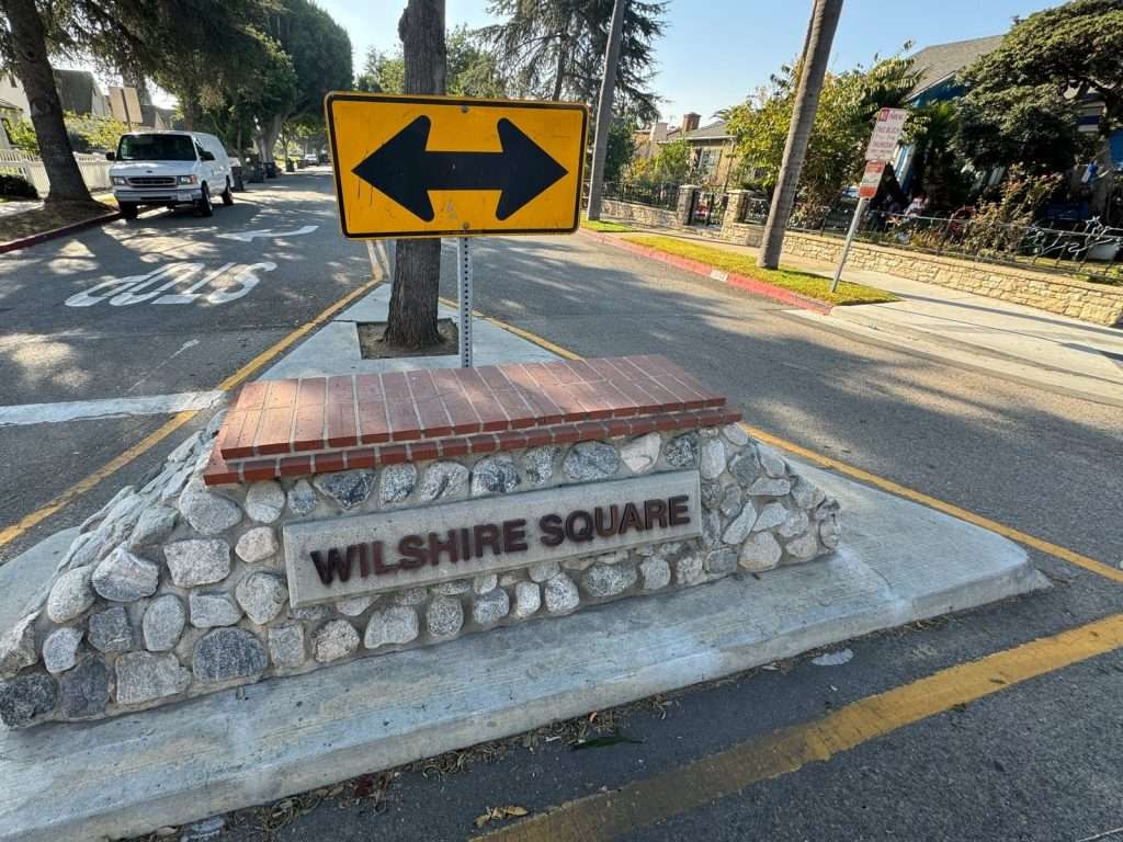 Completed Wilshire Square neighborhood entry monument in Santa Ana with stone masonry, brick cap, nameplate and raised lettering.