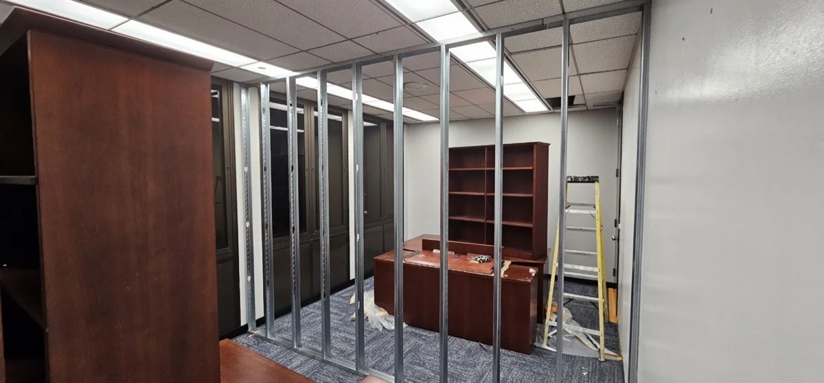 Office interior with walls opened to the studs during selective removal