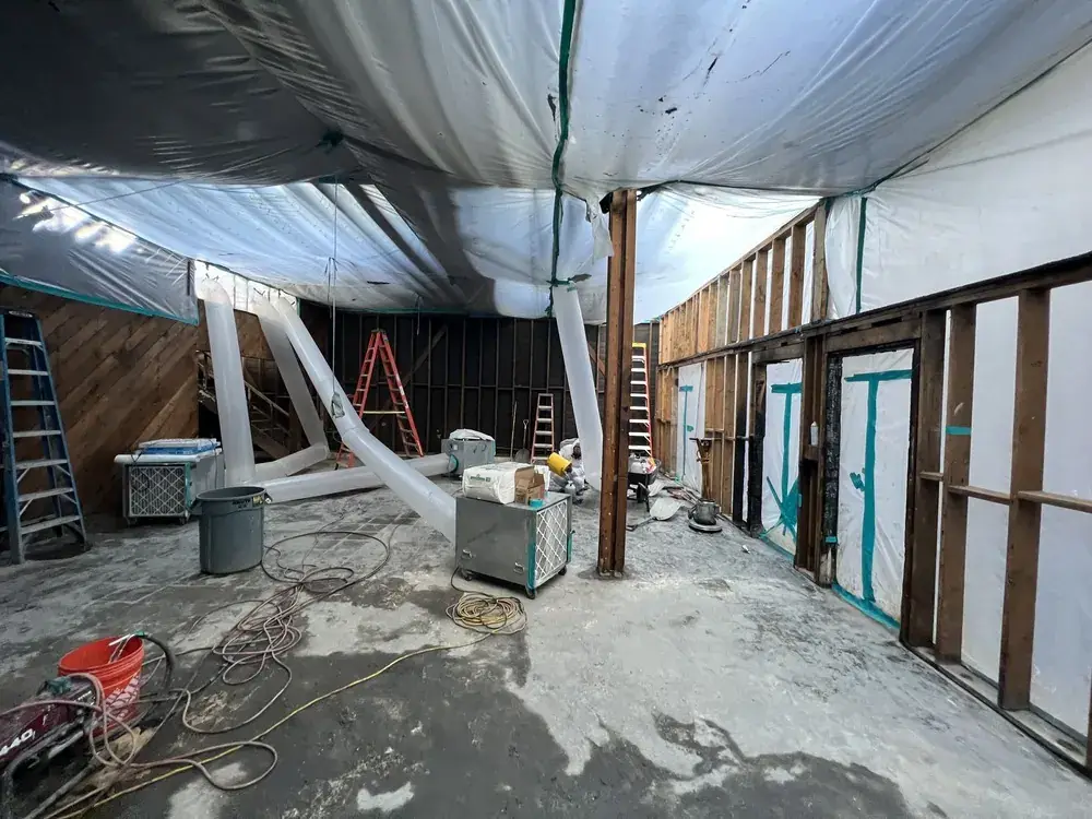 Interior work area with temporary containment and negative air machines during selective removal