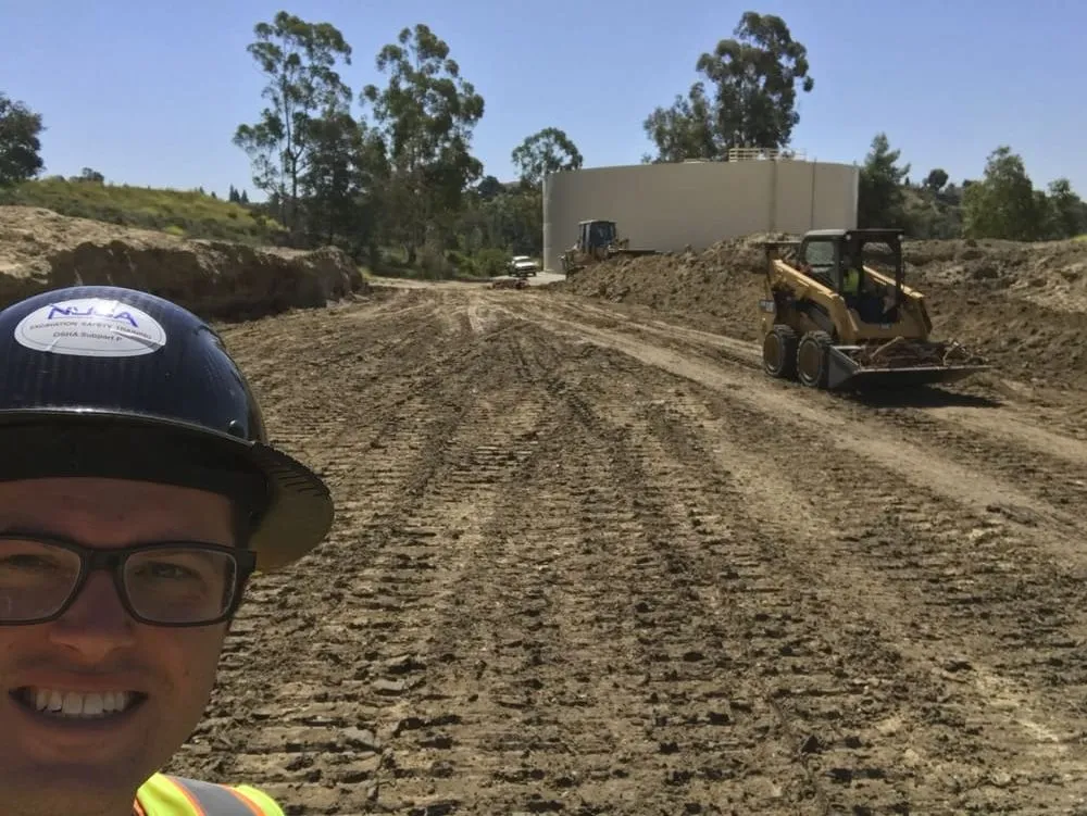 Broad earthwork area with compact equipment and visible grading operations