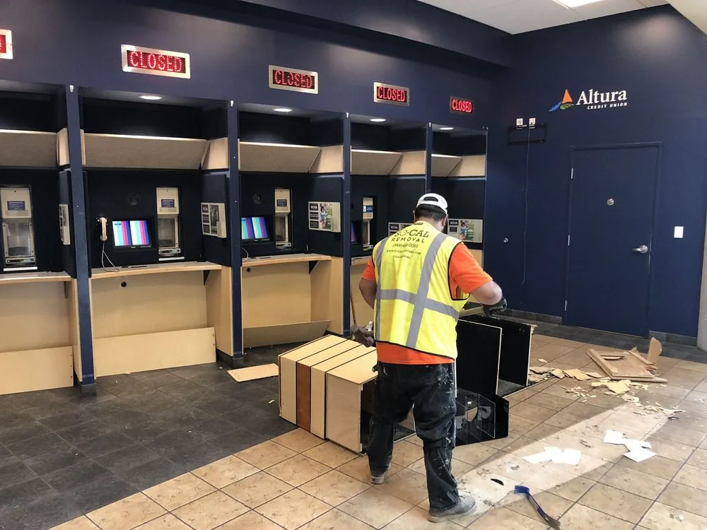 SoCal Removal worker dismantling fixed counter and casework in a commercial interior