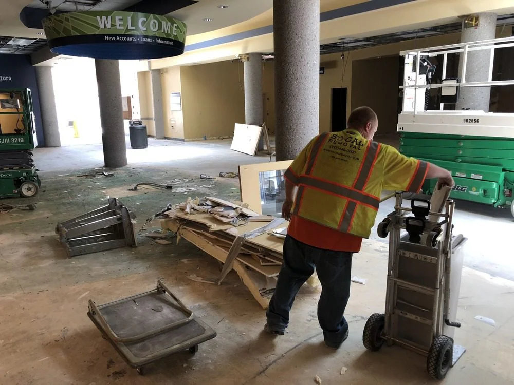 Crew member moving debris during interior removal in a commercial building