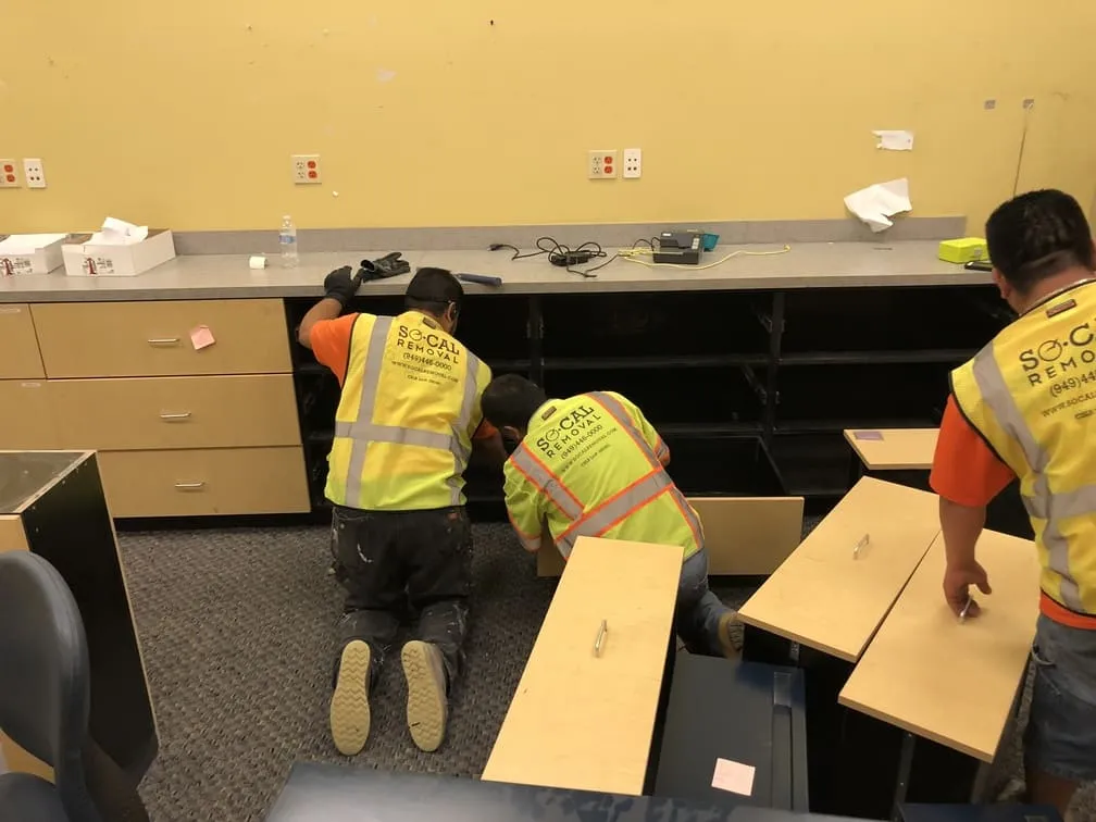 SoCal Removal crew disassembling built-in casework in a commercial interior