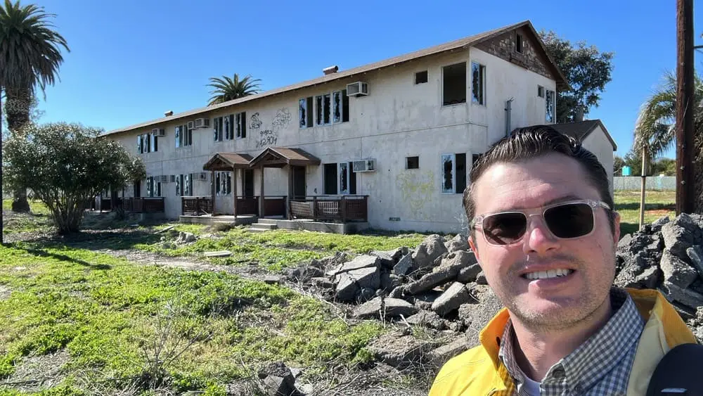 Andre Abajian standing near an existing multi-unit building and removed concrete